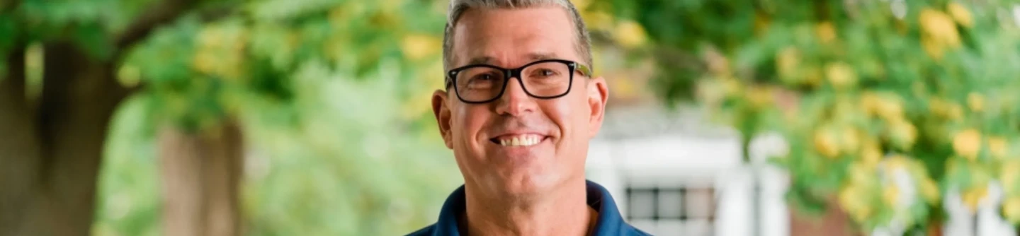 Smiling man with glasses.