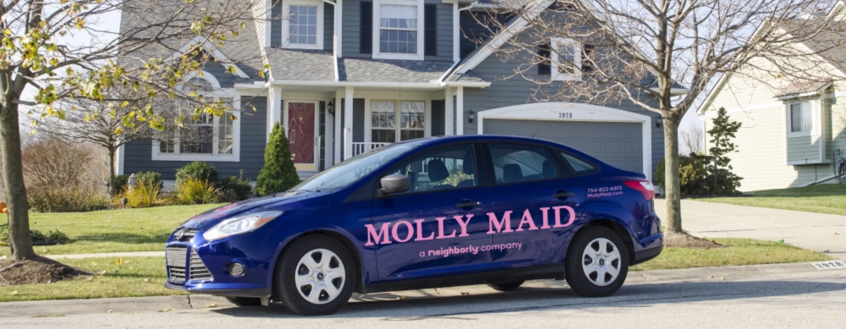 Branded Molly Maid car parked in front of home.