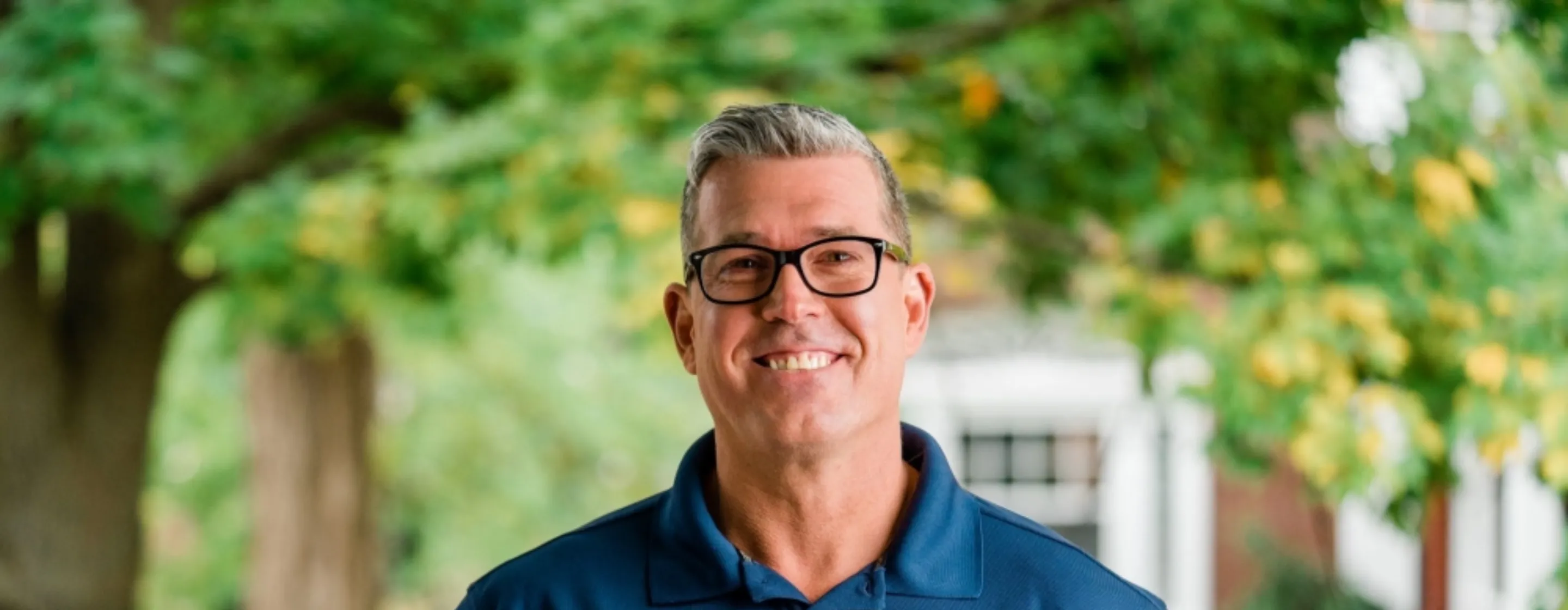 Smiling male technician wearing a branded polo shirt.