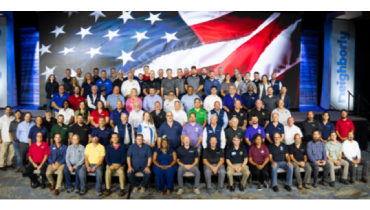 Group photo in front of the American flag.